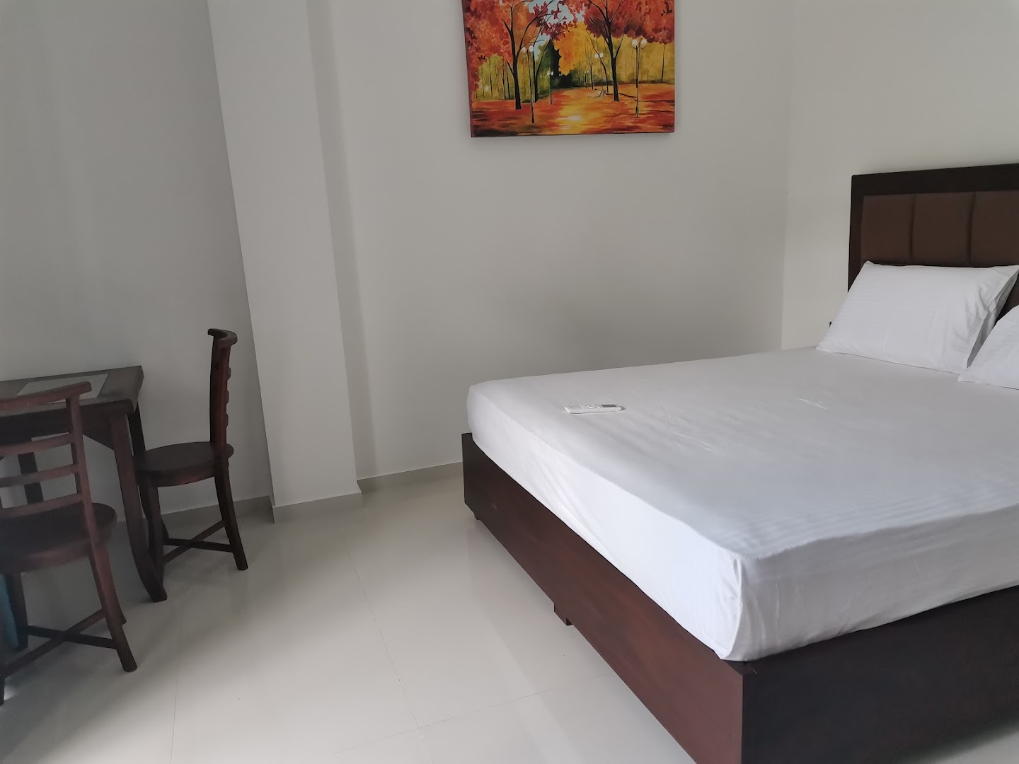 Bright bedroom with a neatly made bed and timber furniture