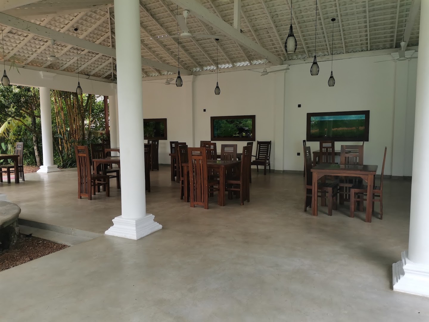 Open dining pavilion with white columns and timber tables